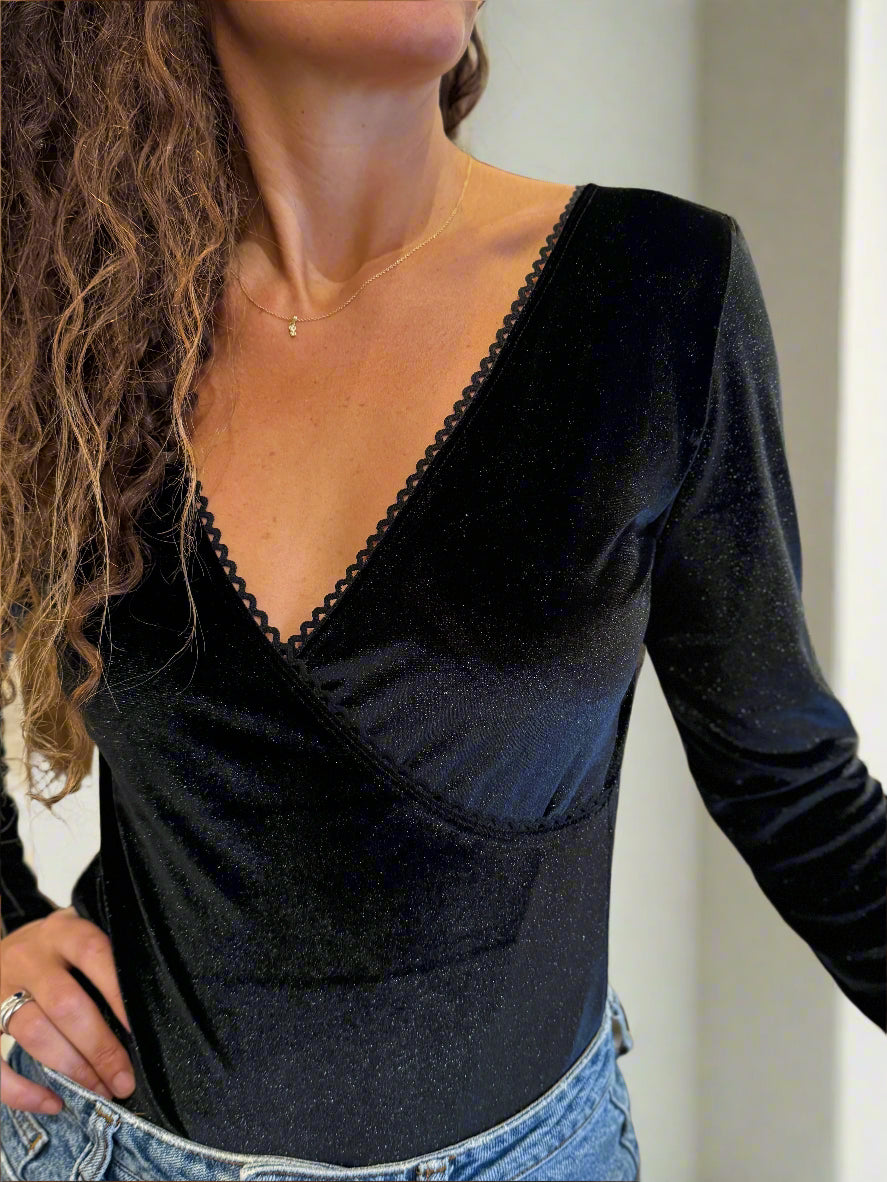 a black velvet bodysuit with long sleeves and deep V-neckline.